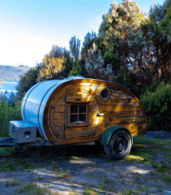 Small Custom camper design parked in a natural forest setting.